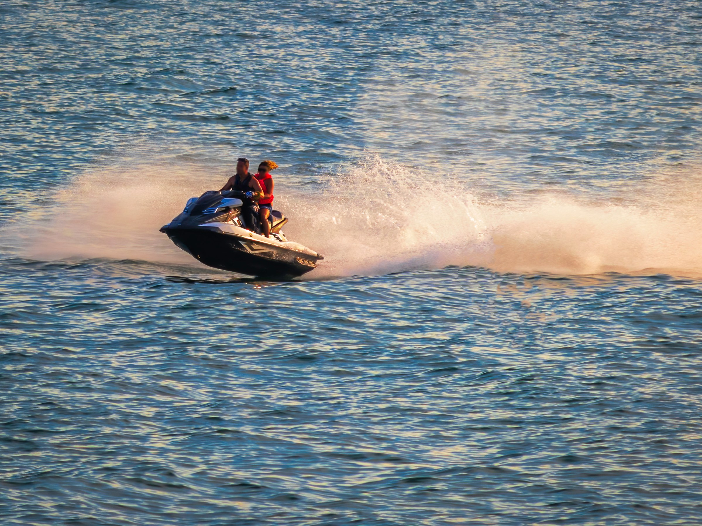 a person riding on the back of a boat in a body of water