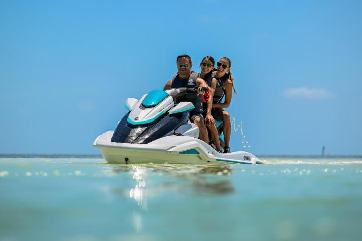 a group of people riding on the back of a boat in the water